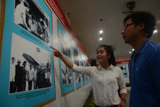 Bạn Lê Thủy Ngân đang giải thích những bức ảnh về cố Tổng bí thư Nguyễn Văn Linh cho người bạn của mình trong buổi triển lãm ảnh tại Nhà Văn hóa thanh niên - Ảnh :Duyên Phan