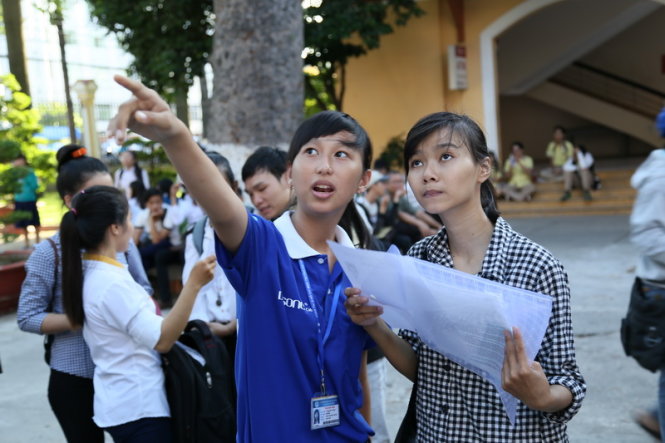 Sinh viên tình nguyện trường ĐH Sài Gón đang hướng dẫn thí sinh lên phòng thi trong ngày tập trung tại cụm thi ĐH Sài Gòn kỳ thi THPT Quốc Gia sáng 30/6 - Ảnh: Như Hùng