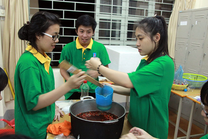 Các sinh viên đang chế biến nươc mắm chấm cho phần cơm của thí sinh - Ảnh: Tr.Tân