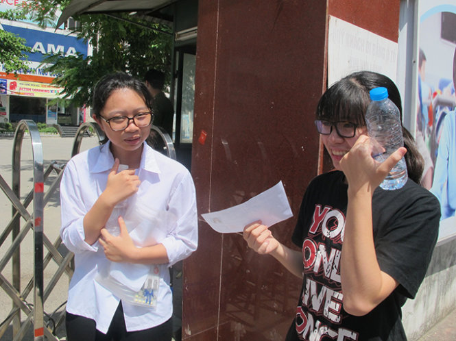 Hai thí sinh nữ trao đổi với nhau về bài làm văn sau khi ra ngoài cổng trường - Ảnh: Thân Hoàng