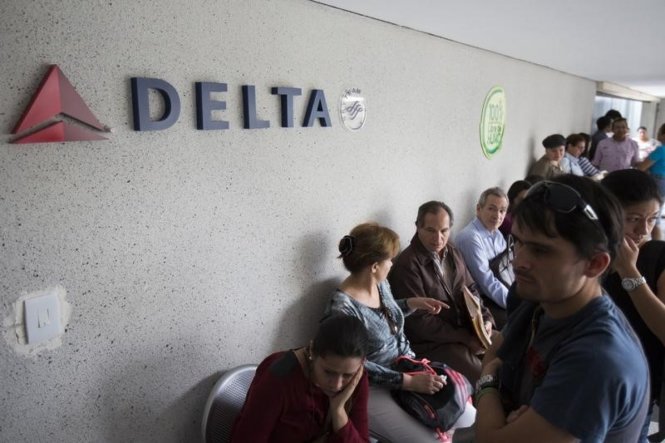 Hành khách chờ giao dịch ở văn phòng Hãng hàng không Delta  Ảnh: Reuters