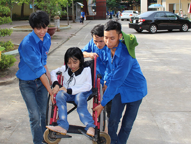 Bạn Lê Thị Liên được các anh thanh niên tình nguyện giúp đưa lên phòng thi tại điểm thi ở Trường THPT chuyên Lam Sơn (Thanh Hóa) - Ảnh: Hà Đồng