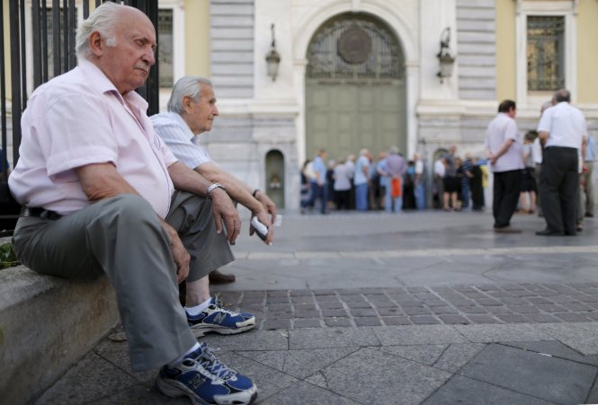 Những người về hưu ngồi chờ rút tiền bên ngoài một chi nhánh của Ngân hàng quốc gia Hi Lạp tại thủ đô Athens ngày 6-7 - Ảnh: Reuters
