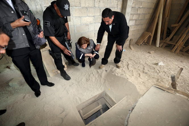 Bộ trưởng Tư pháp Mexico Arely Gomez Gonzalez (thứ hai từ phải sang) xem xét lối ra của đường hầm dài 1,5km bên trong căn nhà đang xây dựng, hôm 12-7  Ảnh: Reuters