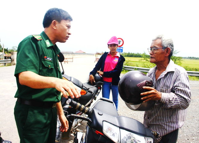 Ông Khom Mon, người ở xã Crua, huyện Svay Chrum, tỉnh Svay Rieng (Campuchia), trò chuyện với biên phòng Việt Nam trên cây cầu Hữu Nghị 1 Ảnh: SƠN LÂM