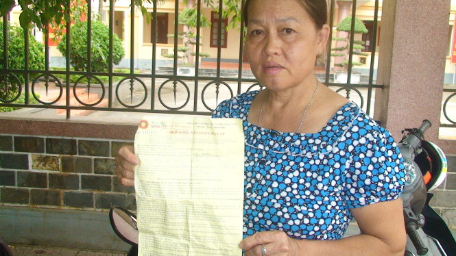 Bà Lê Thị Tình đang cầm đơn trình bày sự việc với báo chí - Ảnh: Văn Định