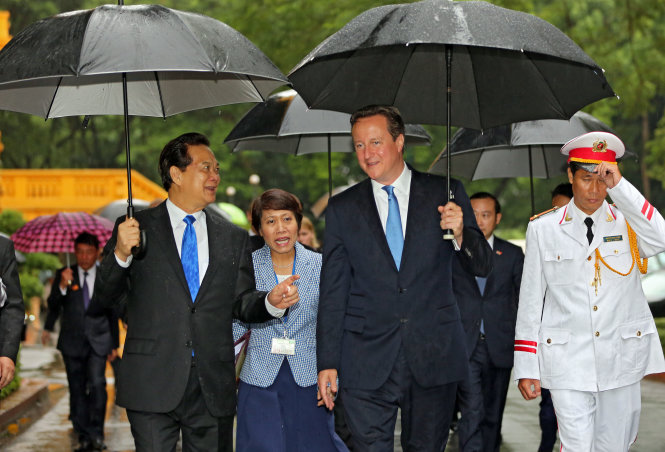 Thủ tướng Nguyễn Tấn Dũng và Thủ tướng David Cameron trò chuyện dưới cơn mưa nhỏ - Ảnh: Việt Dũng