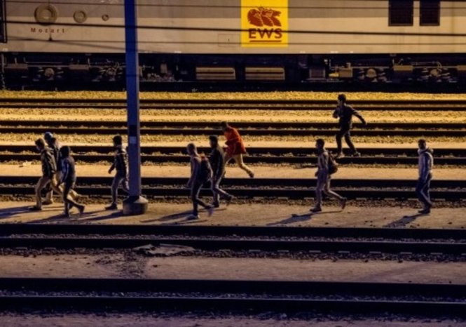 Nhiều người nhập cư chạy bộ trên khu đường ray xe lửa của Eurotunnel tối 28-7 - Ảnh: AFP