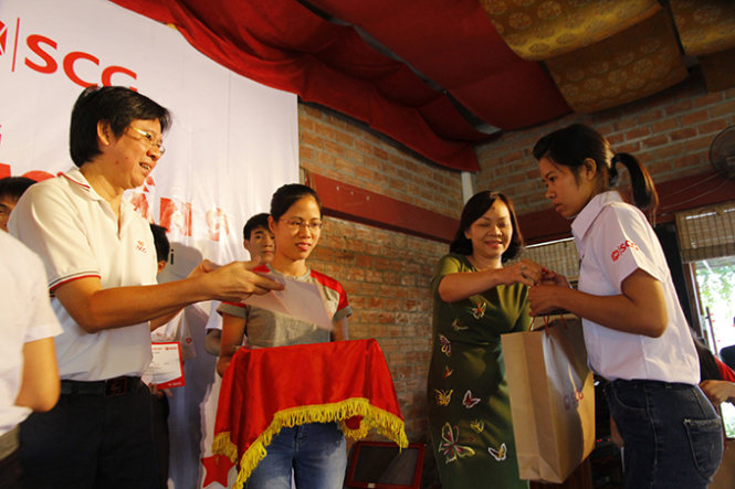 Bà Ngô Thị Thu An, Ủy viên Ban biên tập báo Tuổi Trẻ và đại diện tập đoàn SCG trao các suất học bổng và quà cho các em học sinh - Ảnh: Nam Trần