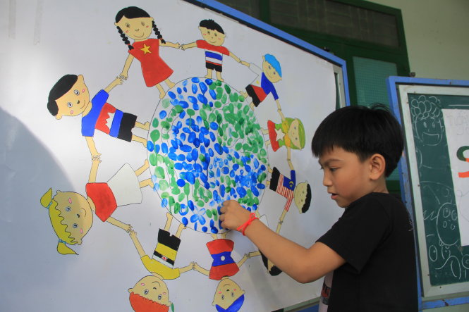 Một học sinh in dấu tay lên bức tranh Chung tay ASEAN Ảnh: TƯỜNG HÂN