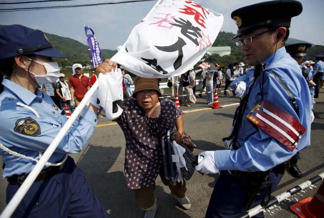 Người biểu tình bị cảnh sát chặn lại trước cửa vào Nhà máy điện Sendai ở Kagoshima ngày 9-8 - Ảnh: Reuters