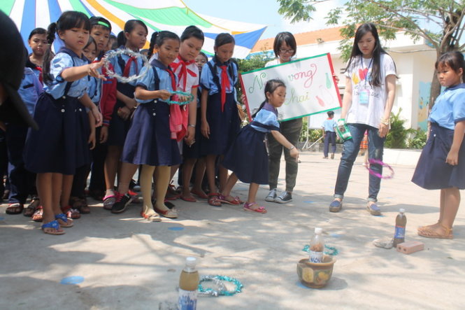 Các em học sinh tham gia tranh tài qua trò chơi Ném vòng cổ chai - Ảnh: Khoa Nguyễn