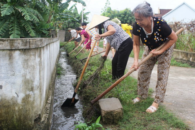 Người dân xã Hưng Long, huyện Hưng Nguyên (Nghệ An) dọn dẹp vệ sinh moi trường sáng 6-10 - Ảnh: Doãn Hòa