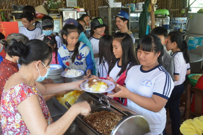 Học sinh dùng cơm tại bếp ăn khuyến học chùa Bửu Nghiêm - Ảnh: T.Nhơn