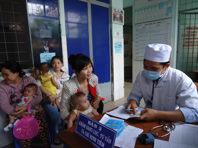 Nhân viên trạm y tế khám cho trẻ trước khi chích ngừa ở TP Biên Hòa  - Ảnh: A Lộc