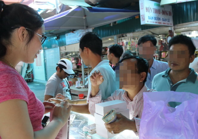 Khách du lịch mua iPhone 6S và 6S Plus nhái tại một cửa hàng di động ở chợ Cốc Lếu (Lào Cai) - Ảnh: PHAN DƯƠNG