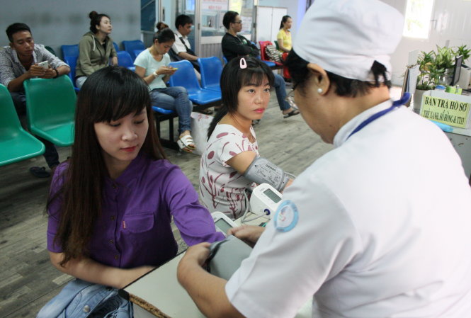 Nhân viên một công ty đi khám sức khỏe định kỳ tại Bệnh viện Q.Bình Thạnh, TP.HCM - Ảnh: Hữu Khoa