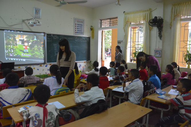 Các tình nguyện viên đứng lớp hướng dẫn tận tình cho học sinh học tiếng Anh - Ảnh: Hồ Văn