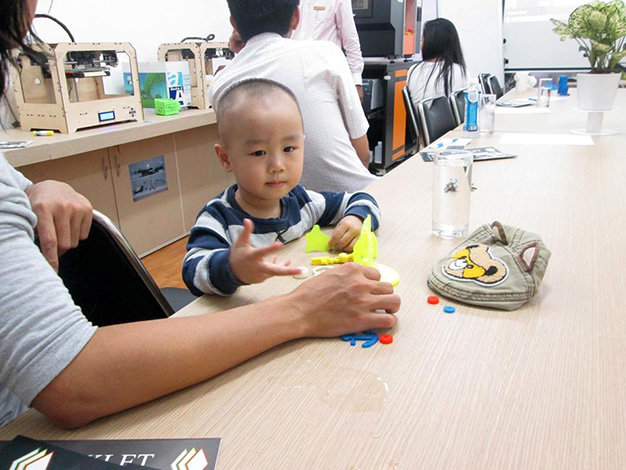 Cậu bé 3 tuổi tỏ ra thích thú với những món đồ chơi ngộ nghĩnh được làm từ chính công nghệ in 3D - Ảnh: Minh Huyền