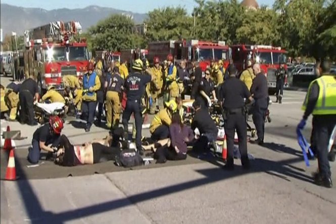 Lực lượng cứu hộ đang chăm sóc những người bị thương ở bên ngoài hiện trường khu vực xả súng tại San Bernardino - Ảnh: Reuters