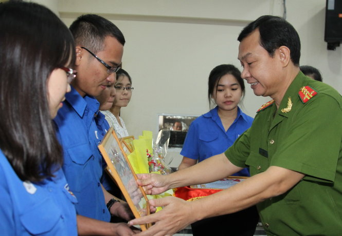 Đại tá Đinh Thanh Nhàn, phó giám đốc Công an TP.HCM, trao giấy khen cho các tập thể tại hội nghị  chiều 17-12 - Ảnh: Chế Hồng Trung