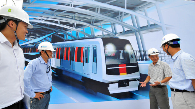 Các kỹ sư Việt Nam và Nhật Bản bên hình phối cảnh con tàu của tuyến đường sắt đô thị số 1 Bến Thành - Suối Tiên, TP.HCM - Ảnh: Minh Đức