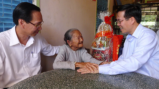 Ông Võ Văn Thưởng (bìa phải) thăm hỏi mẹ VN anh hùng Đặng Thị Khà (xã Tân Hưng, H.Cái Bè, Tiền Giang) - Ảnh: G.Minh