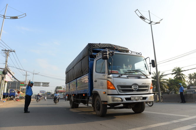 Thanh tra Sở giao thông TP.HCM điều tiết xe có tải trọng trên 5 tấn không được lưu thông vào quốc lộ 1 đoạn từ nút giao Bình Thuận đến giao lộ quốc lộ 1 với đường DT835 vào giờ cao điểm - Ảnh: Hữu Khoa