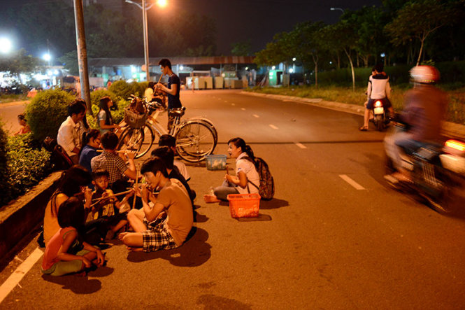 Một nhóm sinh viên ngồi chơi dưới lòng đường dành cho xe máy trong làng đại học Thủ Đức, TP.HCM - Ảnh: Quang Định