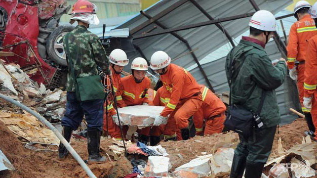 Lực lượng cứu hộ Trung Quốc nỗ lực cứu các nạn nhân kẹt dưới hàng tấn bùn đất Ảnh: AFP