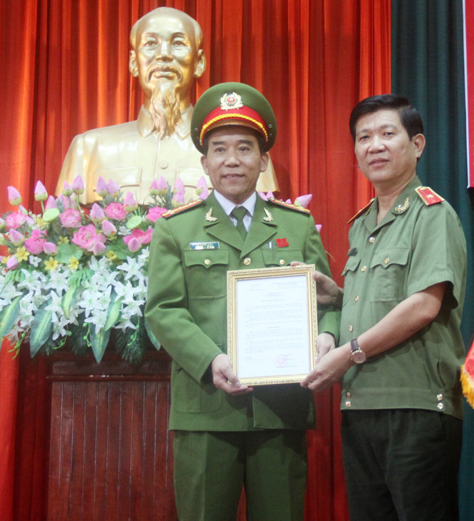 Thiếu tướng Nguyễn Văn Sơn – phó tổng cục trưởng Tổng cục chính trị (Bộ Công an) trao quyết định bổ nhiệm cho đại tá Lê Quốc Dân - Ảnh: Đoàn Cường
