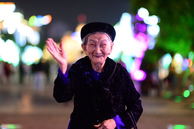 Cụ bà Mai Thị Tròn, 98 tuổi, quê Nghệ An, bà vào Sài Gòn sống cùng con cháu được vài năm chào năm  mới với mọi người trên phố đi bộ Nguyễn Huệ tối 31 -12 -Ảnh: Thanh Tùng