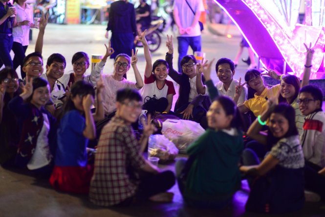 Một nhóm bạn trẻ ngồi chơi trên đường Nguyễn Huệ -Ảnh: Thanh Tùng