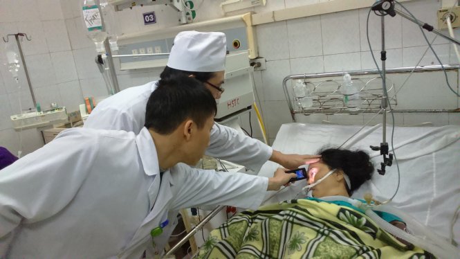 Nạn nhân Lê Thị Nguyên (52 tuổi, Nông Cống, Thanh Hóa) được chăm sóc tại Bệnh viện Đa khoa Thanh Hóa 
đêm 1-1-2016 - Ảnh: Hà Đồng
