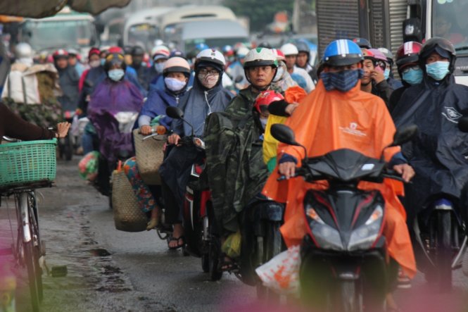 Hàng ngàn người mặc áo mưa quay lại TP.HCM làm việc sau kỳ nghỉ tết dương