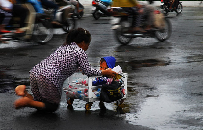 Bà Thu Dày (ngụ thị trấn Thới Bình, huyện Thới Bình, Cà Mau) bị tật nguyền đôi chân. Hằng ngày bà mang theo cậu con trai mới hơn 2 tuổi ra tận nội ô TP Cà Mau bán vé số kiếm sống.