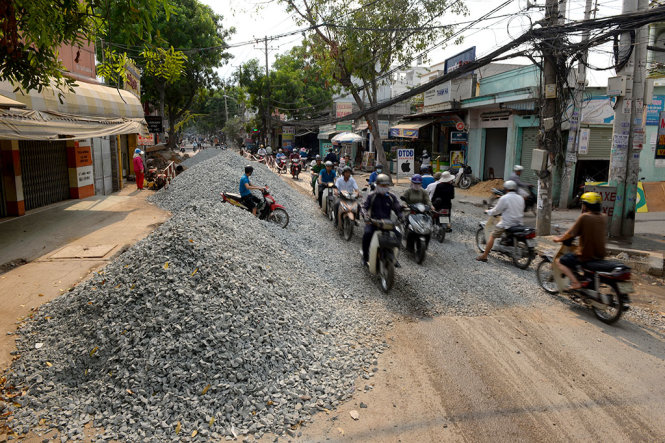 Trước cửa nhà của nhiều hộ dân trên đường Nguyễn Văn Quá (P.Đông Hưng Thuận, Q.12, TP.HCM) bị đống đá chắn ngang, xe ra vào rất khó khăn - Ảnh: Hữu Khoa