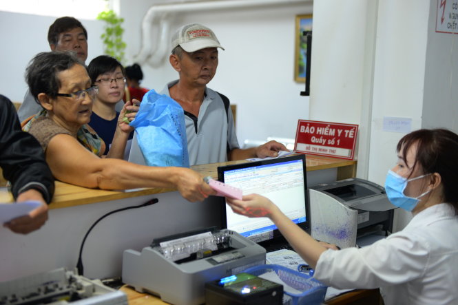 Người dân có bảo hiểm y tế đóng tiền khám bệnh và mua thuốc tại Bệnh viện Quận Thủ Đức, TP.HCM - Ảnh: Hữu Khoa
