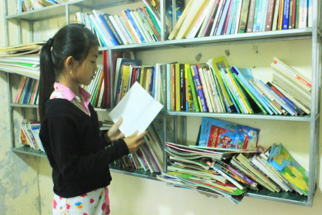 Em Phan Thị Vân, lớp 4/1 Trường tiểu học Phú Đa 3, tham khảo sách tại “Tủ sách yêu thương” - Ảnh: Anh Tú