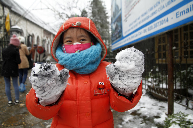Một bạn trẻ tỏ ra thích thú với những tảng tuyết dính trên gang tay - Ảnh: Nam Trần
