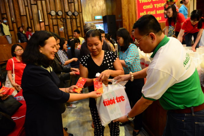 Các nhà hảo tâm trao tặng quà cho các bệnh nhân và người thân bệnh nhân trong chương trình Xuân yêu thương  - Ảnh: Quang Định