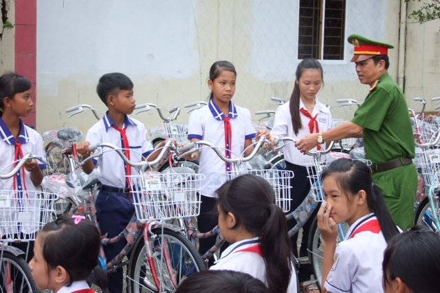 Đại tá Liệt trao xe đạp cho học sinh nghèo - Ảnh: Công an Mỹ Tú cung cấp