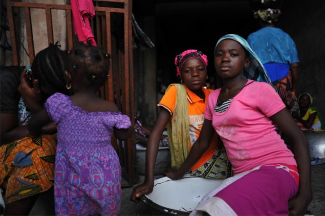 Hai cô gái trẻ Aisha Yakubu và Sahada Al Hassan chờ khách hàng thuê khuân vác tại chợ rau Agbogbloshie, thủ đô Accra của Ghana - Ảnh: PRI