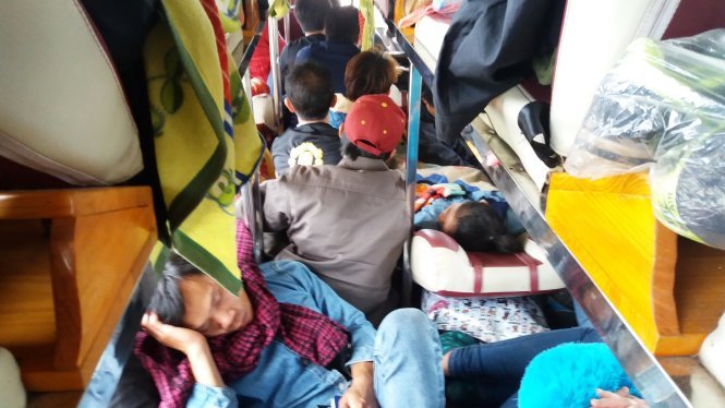 Hành khách nằm ngồi chen chúc trên chuyến xe từ Lào về quê - Ảnh: Doãn Hòa