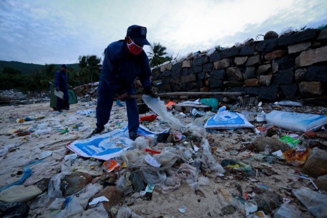 Công nhân môi trường dọn dẹp rác trên đảo Hòn Một. Đây là một trong những điểm đảo có lượng rác lớn dạt vào bờ do không còn người dân sinh sống - Ảnh: Tiến Thành