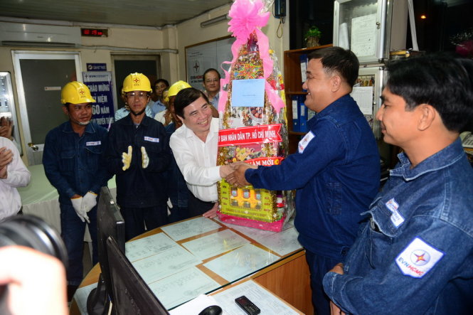 Chủ tịch UBND TP HCM Nguyễn Thành Phong tặng quà cho các cán bộ công nhân trực điện- Điện lực Thủ Thiêm - Ảnh: TTD