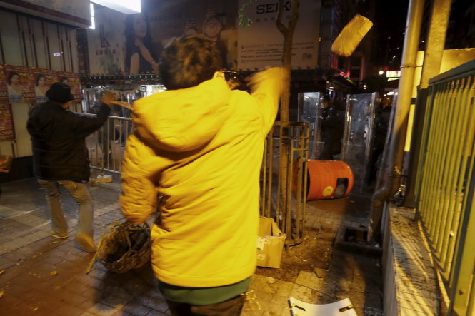 Người biểu tình ném đá về phía cảnh sát - Ảnh: Reuters
