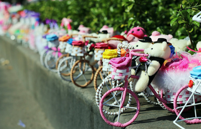 Những con gấu đạp xe có giá khoảng 100.000 đồng mỗi món được bày biện thành hàng dài dọc đường Nguyễn Văn Cừ - Ảnh: Ngọc Hiển