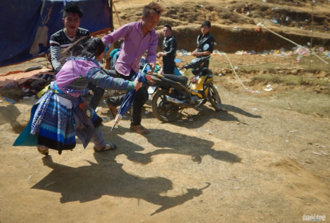 Tan hội, một cô gái Mông bất ngờ bị hai thanh niên kéo - Ảnh: Tiến Thành
