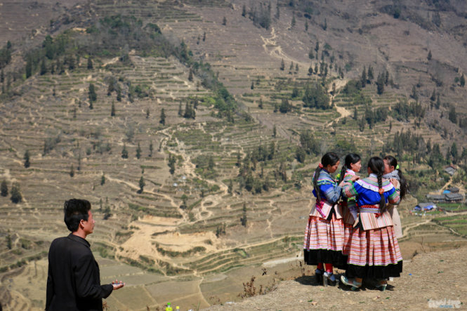 Một chàng trai ngắm nhìn các cô gái Mông trong trang phục truyền thống đi chơi hội - Ảnh: Tiến Thành